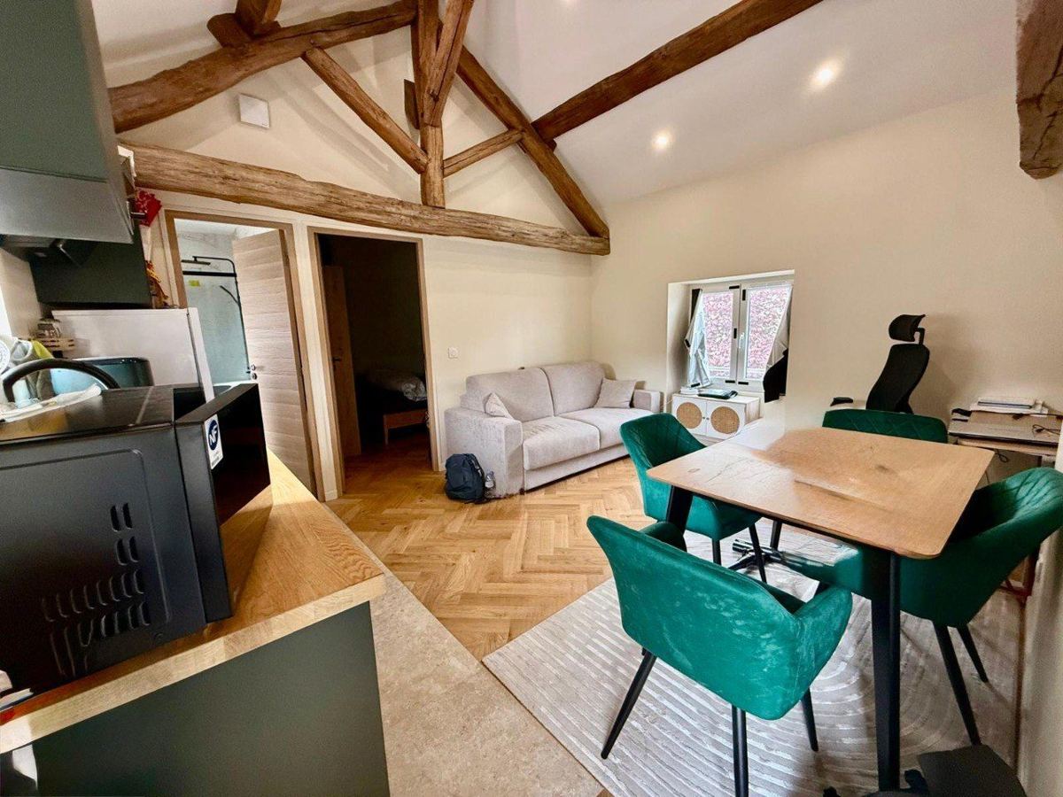 Le séjour après rénovation : charpente apparente et parquet